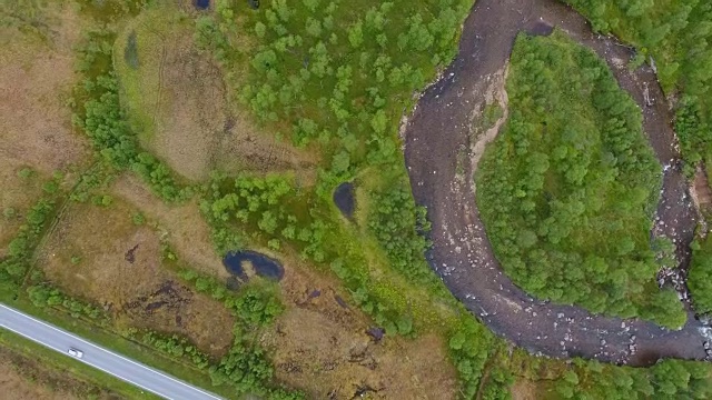 在挪威的夏天，通过绿色的自然的乡村道路的顶视图视频素材