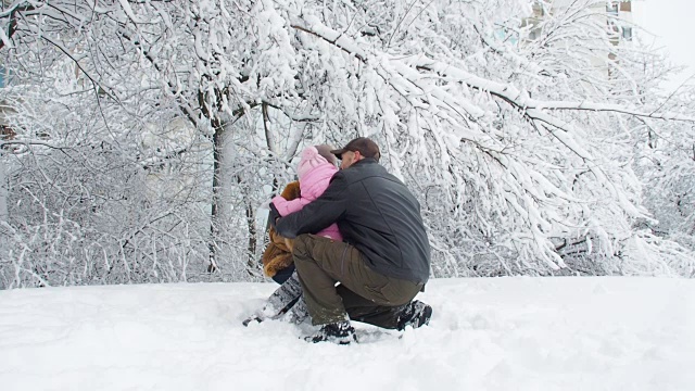 冬季公园的家庭。快乐的一家人在雪中玩耍。视频素材