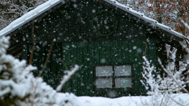 慢镜头:雪天里宁静的森林和小木屋的美丽景色。视频素材