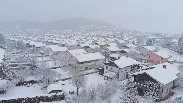 鸟瞰图:在宁静的郊区白雪覆盖的后院和房屋上空飞行。视频素材