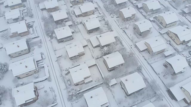 航拍:在积雪的屋顶和郊区街道上空飞行。视频素材