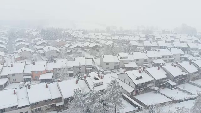 天线:在下雪的日子里，在郊区空旷的街道上空飞行。视频素材