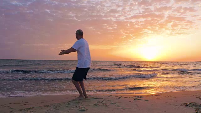 男子训练太极拳，而傍晚夕阳在海边视频素材