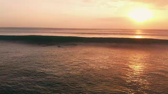 鸟瞰图与海洋和波浪在巴厘岛温暖的日落视频素材