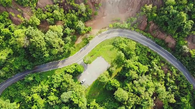 俯视图的乡村道路，路径通过绿色的森林和泰国的乡村，俯视图无人机空中视频。视频素材