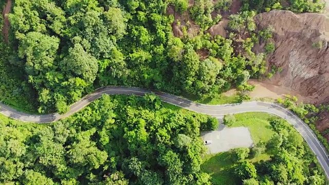 俯视图的乡村道路，路径通过绿色的森林和泰国的乡村，俯视图无人机空中视频。视频素材