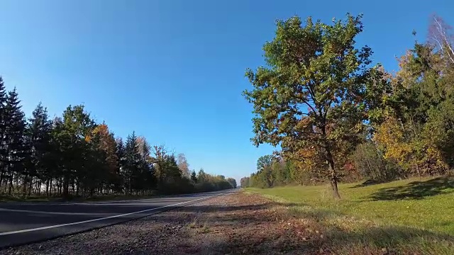 汽车行驶在秋天的乡村道路上，停在路边。视频素材