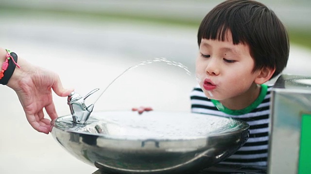 小男孩喝自来水视频素材