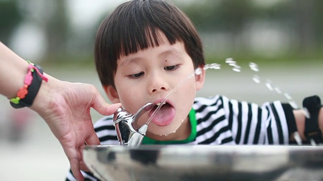 小男孩喝自来水视频素材