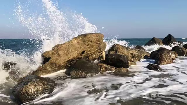 慢镜头海浪撞击大海中的岩石视频下载