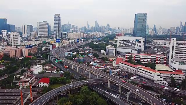 汽车在桥梁道路上行驶，形成了带有摩天大楼的曲线公路。班纳高速公路鸟瞰图，Klong Toey在建筑概念结构，城市城市，曼谷，泰国。视频素材