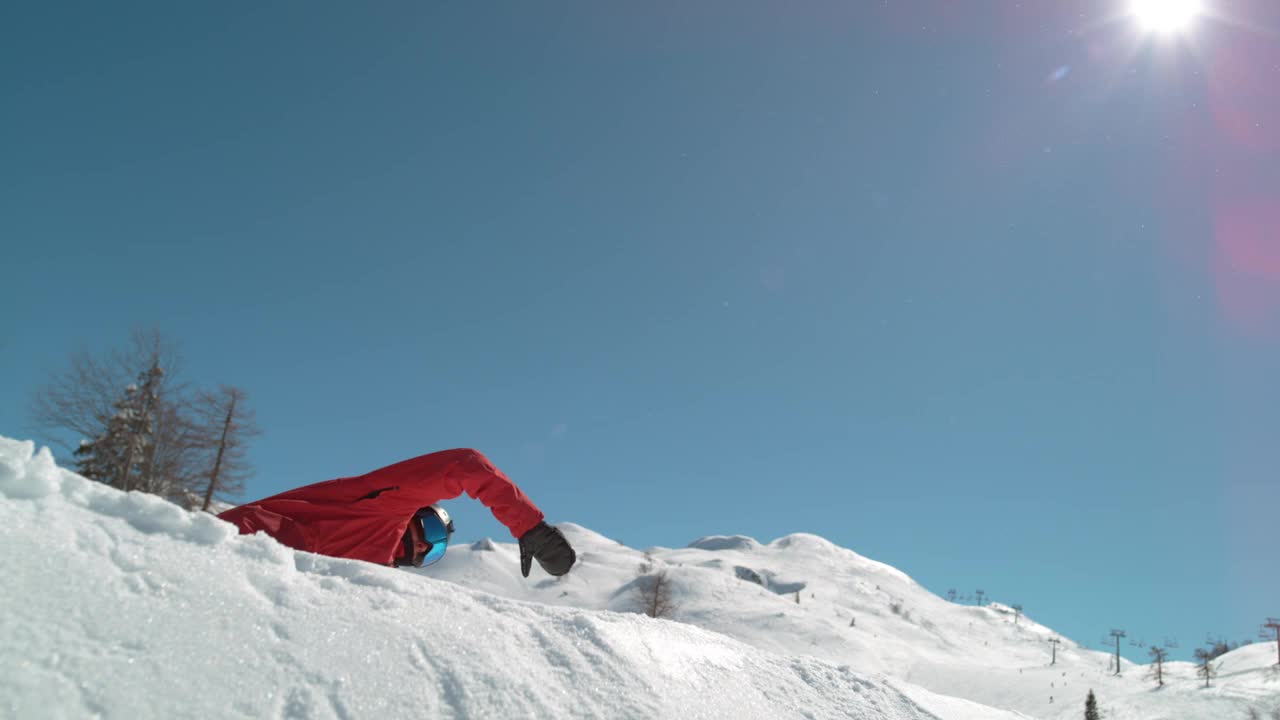 慢动作:冬天的阳光照耀在滑雪运动员做旋转抓斗。视频素材