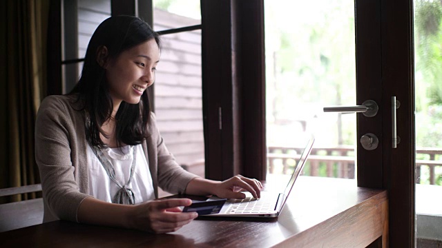 年轻女子在家里用信用卡网上购物视频素材