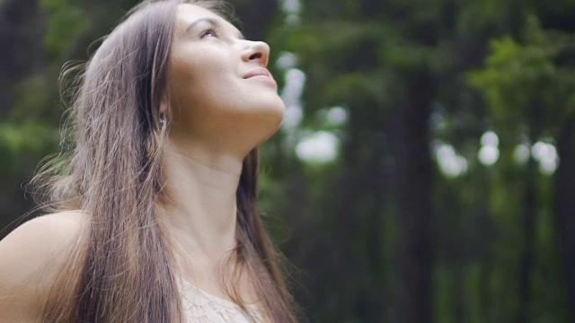 快乐的女人深深地与自然联系在一起感到团结在森林户外微笑视频素材