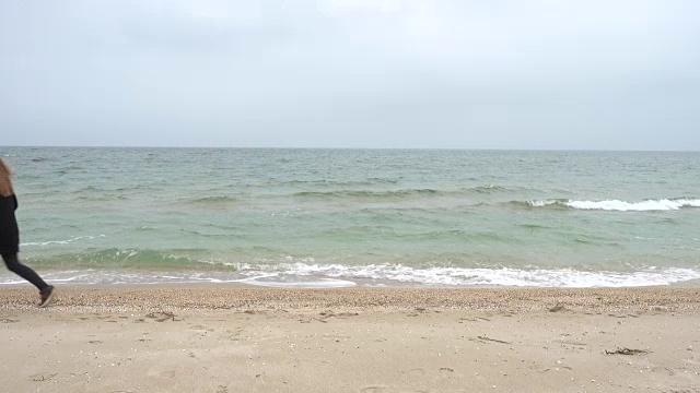 那个女孩在海滩上散步。在海滩上拍摄。视频素材