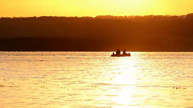 夕阳下的海湾和渔船的剪影视频素材