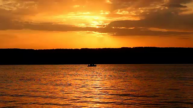 夕阳下的海湾和渔船的剪影视频素材