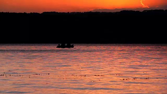 夕阳下的海湾和渔船的剪影视频素材