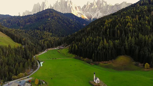 无人机拍摄的美丽的Dolomites山和日落的光和圣约翰在拉努伊教堂。视频素材