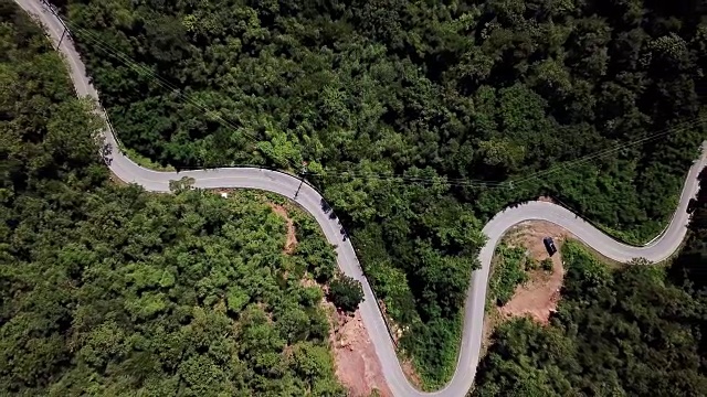 鸟瞰图蜿蜒的道路在森林和汽车驾驶，安全驾驶的概念视频素材