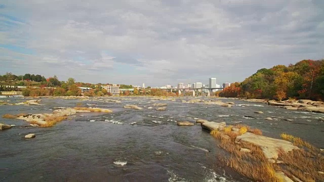 无人机-飞越河流朝向城市的秋天视频下载