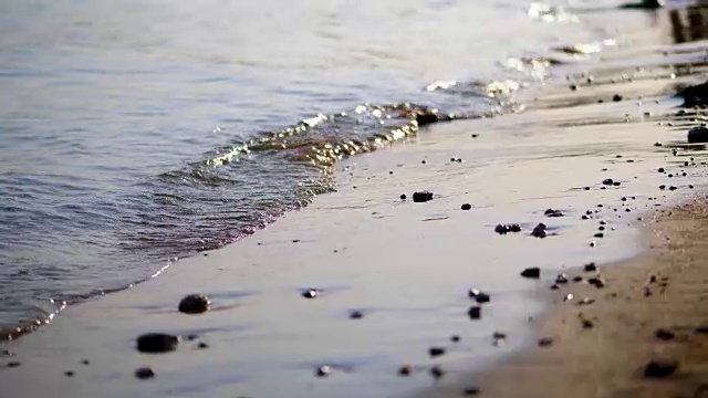 近景，海浪，潮汐，沙滩上的海浪。在阳光的照耀下，夏日的夕阳温暖视频素材