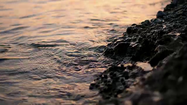 近景，海浪，潮汐，沙滩上的海浪。在阳光的照耀下，夏日的夕阳温暖视频素材