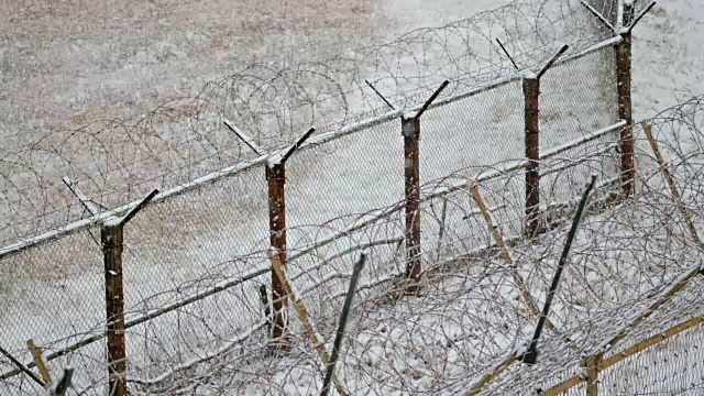 雪花落在韩国和朝鲜之间非军事区(DMZ)的军事围栏——高城郡(Goseong-gun)视频素材