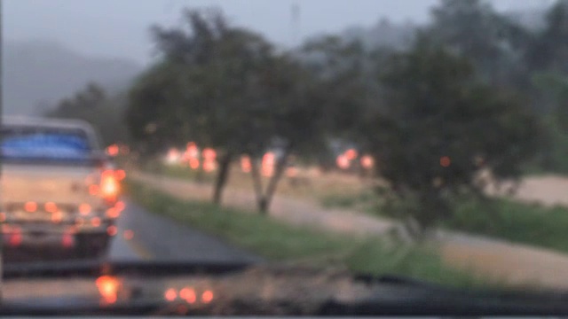 驾驶汽车在雨天和水淹没道路视频素材