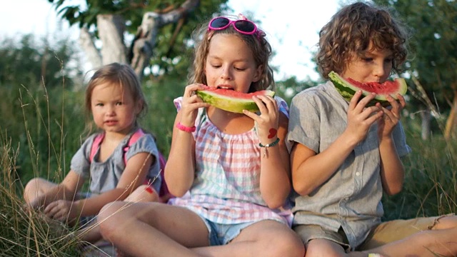 孩子们喜欢吃西瓜，并竖起大拇指。类。健康食品，暑假视频素材