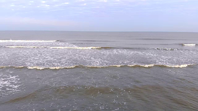 一浪一浪地涌向岸边，动作缓慢。海鸥飞过海浪视频素材