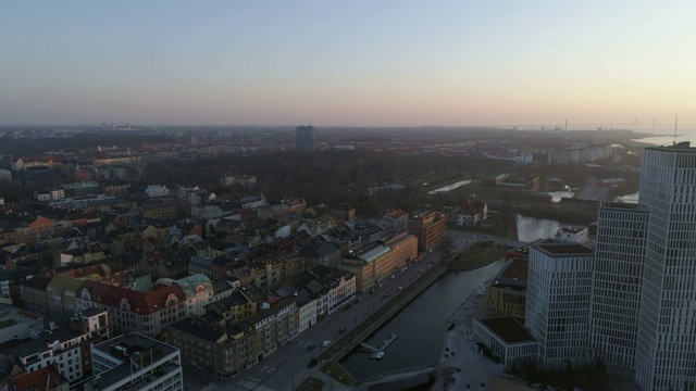 鸟瞰图Malmö城市景观在日落。无人机飞过城市上空，飞向现代摩天大楼视频下载