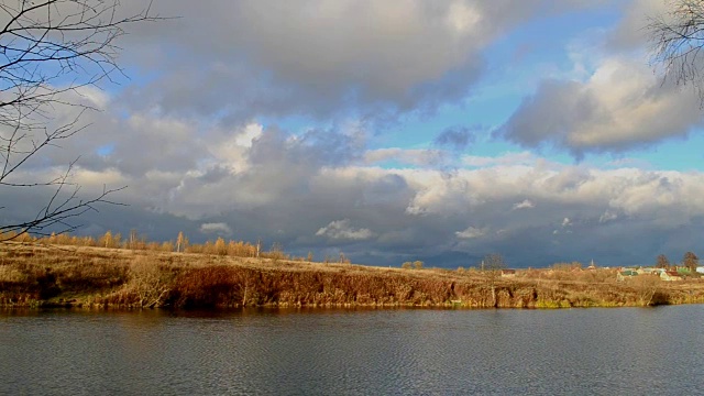 戏剧性的天空。沉重的乌云。晒干的黄草。河。秋天的风景。视频素材