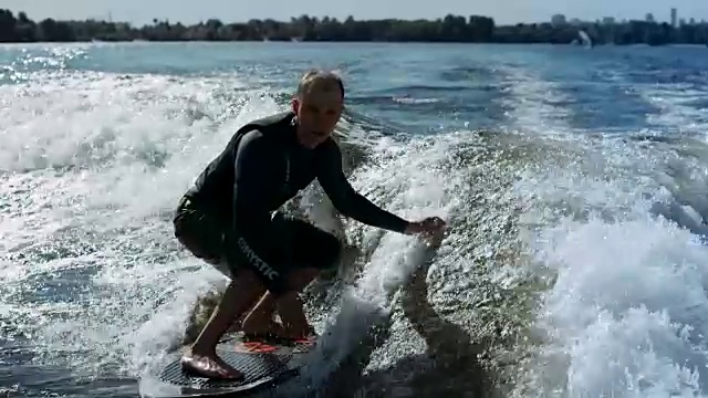 运动的男人在波浪上冲浪的慢动作视频素材