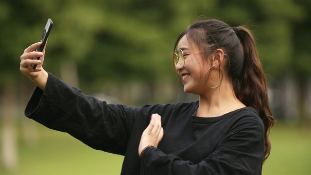 亚洲大学女孩使用手机视频在校园里聊天视频素材