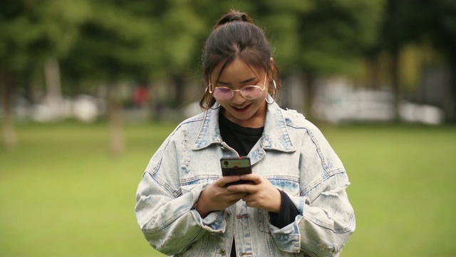 亚洲女大学生在校园里使用手机视频素材