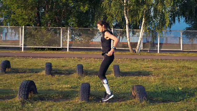 运动女孩跑障碍用轮子，慢动作视频素材