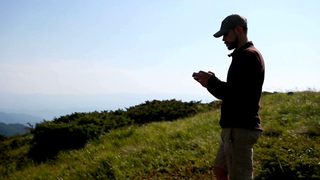 年轻人站在夏日山崖上视频素材