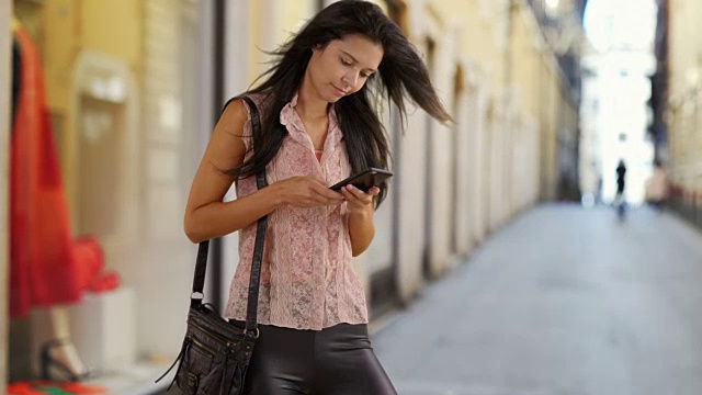 漂亮的白人女人在外面用智能手机发短信视频素材