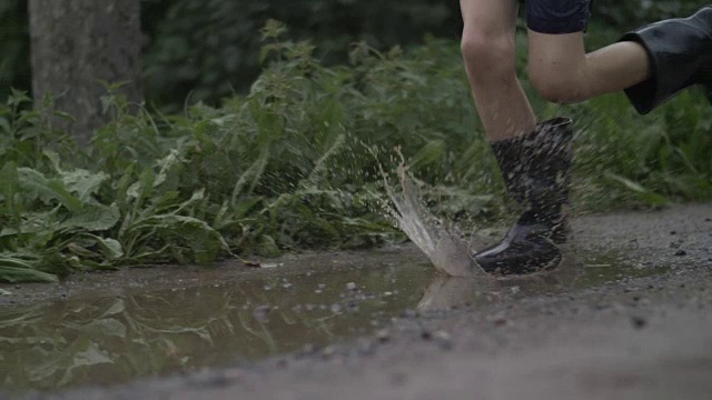 近距离的脚跑过水坑，慢动作，水花，户外视频素材