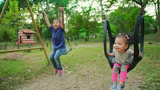 SLO MO两个小妹妹在秋千上享受生活。视频素材