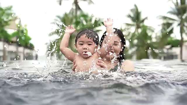 宝宝和妈妈在游泳池里游泳视频素材