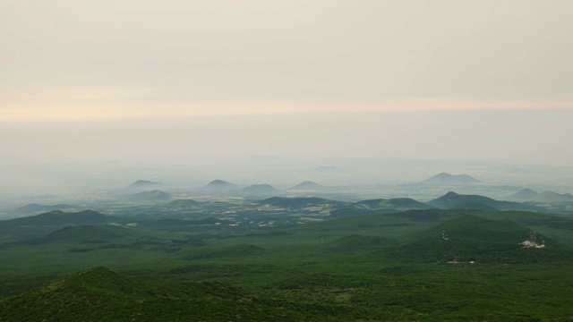 在济州岛，雾笼罩着植被和火山锥视频素材