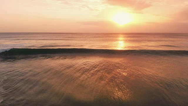 鸟瞰图与海洋和波浪在巴厘岛温暖的日落视频素材