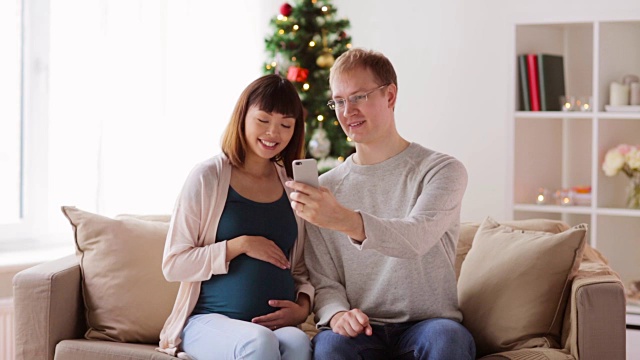 一名男子和一名孕妇在圣诞节自拍视频素材