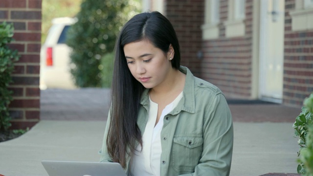 一位漂亮的女大学生在上课前使用笔记本电脑视频素材