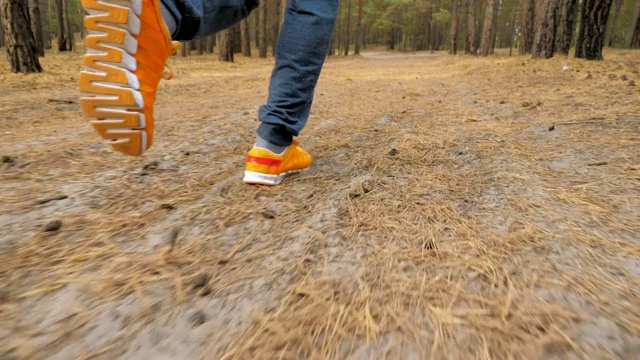 跑步者的脚在乡村道路上奔跑的特写。视频素材