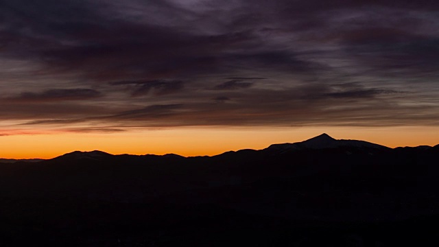 4k镜头的日出时间在山上与五颜六色的云。雄伟的山景与五彩缤纷的云雾。戏剧性的天空。视频下载