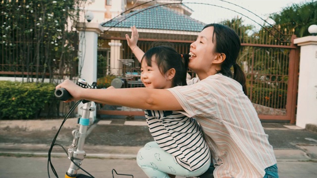 年轻的母亲和女儿骑自行车视频素材