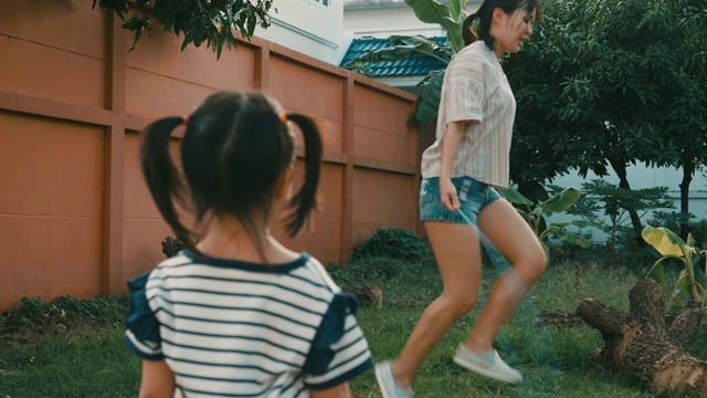 黄昏时分，小女孩看着妈妈跳绳视频素材